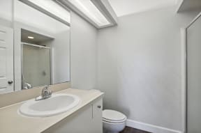 A white sink with a silver faucet is on a countertop in a bathroom.